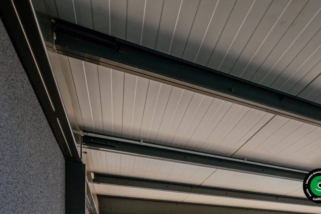 Detail konštrukcie strechy s oceľovými nosníkmi a panelmi.