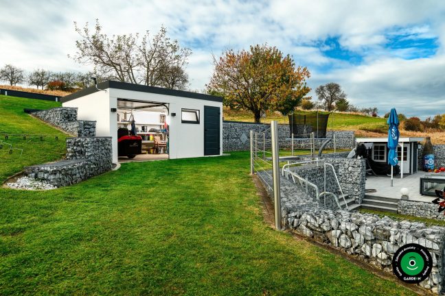 Otvorená garáž s uloženým náradím a záhradnou technikou vnútri