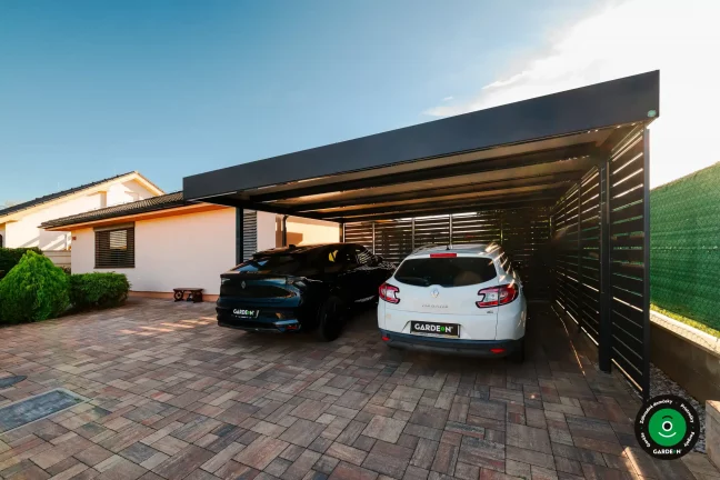 Prístrešok s čiernym a bielym autom chránenými pod pevnou strechou