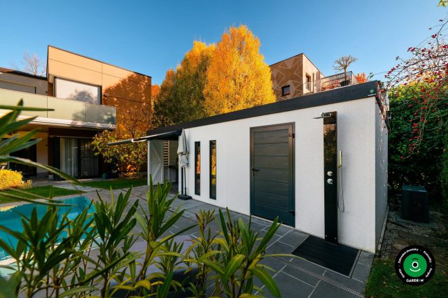 Záhradný domček pri bazéne obklopený jesennými stromami