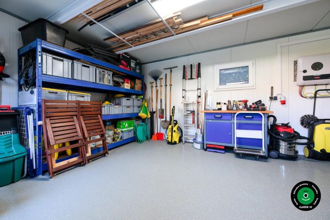 Záhradné náradie zoradené pri modrých policových regáloch